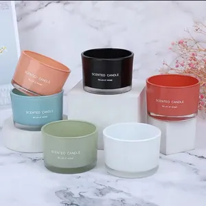 Detailed view of colorful glass scented candle jars in various pastel and bold colors