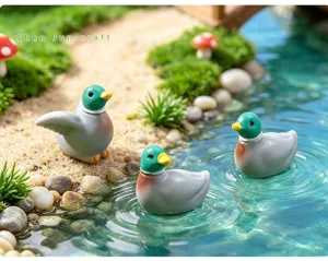 Vista detallada de figuras de patos en miniatura en un estanque de jardín de hadas