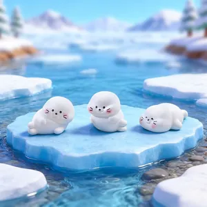 Trois figurines de bébés phoques miniatures sur un iceberg bleu pour micro-paysage