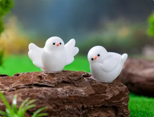 Close-up of cute mini white bird figurines in resin for DIY micro landscape gardening