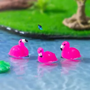 Trois figurines miniatures de flamants roses en résine dans une scène de micro-paysage