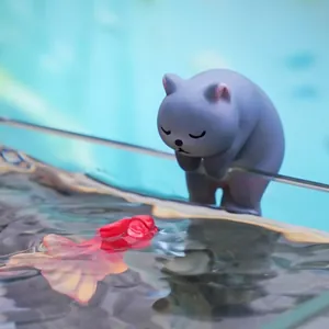 Adorable grey cat figurine hanging on aquarium edge, cute miniature DIY tank decoration