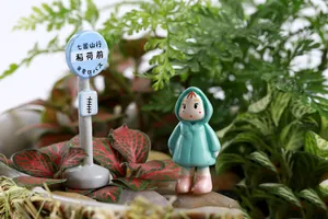 Miniatur-Mädchen im Regenmantel mit Bushaltestellenschild für Mikro-Landschafts-Deko