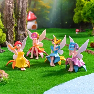 Set of four colorful fairy figurines holding LOVE letters in a miniature garden scene.