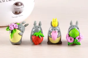 Detailaufnahme von vier niedlichen Totoro-Figuren aus Harz mit Erdbeeren und Blumen