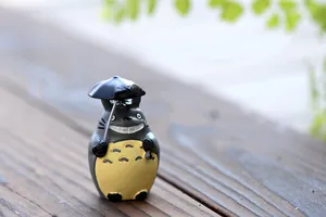 Detailreiche Nahaufnahme einer Totoro-Miniaturfigur mit Schirm für die Gartendekoration.