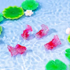 Schattige mini roze hars goudvis beeldjes in een blauwe vijver met waterlelies