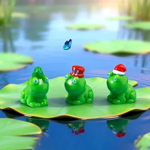 Set di tre statuine di rane festive con cappelli a tema su una foglia di loto nello stagno
