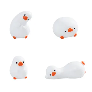 Set of four cute miniature white duck figurines in various playful poses for decor.