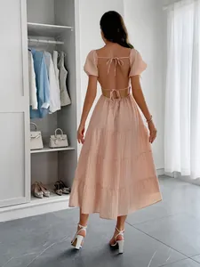 Robe longue rose dos nu élégante avec manches bouffantes et détails à nouer pour l'été.