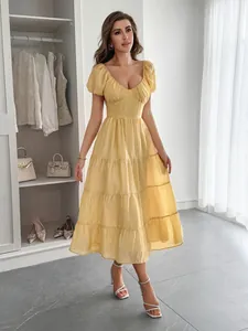 Robe midi jaune élégante à manches courtes et jupe à volants pour les vacances.