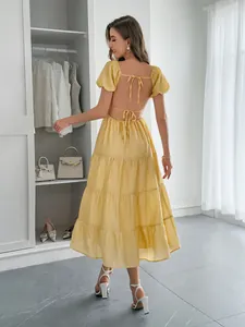 Vue détaillée de dos de la robe midi jaune à volants avec dos nu et liens à nouer.