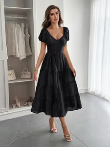 Modèle portant une robe longue noire à volants dans un dressing intérieur de luxe.