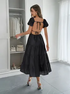 Robe longue noire à volants et dos nu élégante avec détails à nouer pour l'été