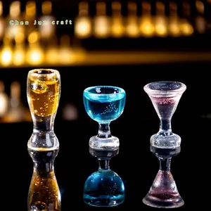 Set of three miniature dollhouse cocktail glasses with colorful juice for DIY decor.