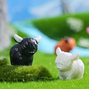 Miniatuur hooglandkoe figuren in zwart en wit voor DIY feeëntuin landschapsarchitectuur