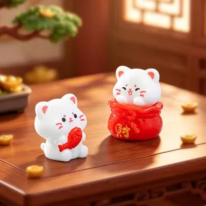 Set of two cute miniature white lucky cat figurines on a wooden table with gold ingots