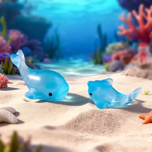 Twee schattige miniatuur blauwe hars walvis en dolfijn op een zandige zeebodem