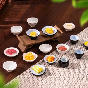 Collection of miniature dollhouse plates and bowls with colorful food models on a table