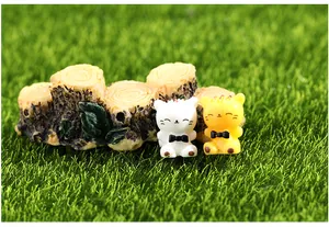 Pair of cute miniature resin cat figurines with realistic wood stump on green moss grass