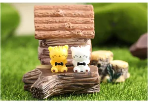 Detailed close-up of two cute miniature resin cat figurines for moss micro landscape DIY