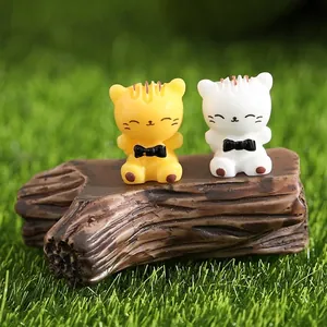 Pair of miniature resin cat figurines sitting on a tree stump for micro landscapes