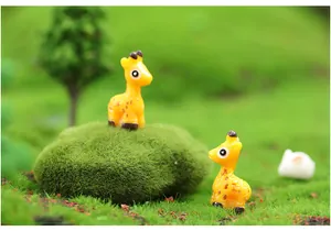 Adorable miniature resin giraffe figurines set on green moss for DIY micro landscape.