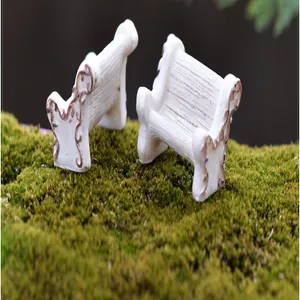 Close-up of two miniature white resin garden benches for fairy garden micro-landscape decoration