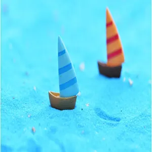 Vue détaillée de voiliers miniatures de style méditerranéen sur sable bleu pour aquarium