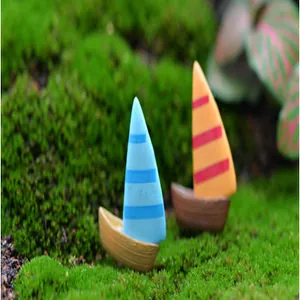 Vue macro de voiliers miniatures méditerranéens sur une surface de mousse verte