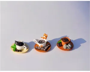 Close-up van drie verschillende miniatuur katten- en dessertornamenten voor landschap