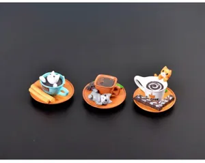 Gedetailleerd overzicht van drie miniatuur kattenfiguren met koffiekopjes en desserts