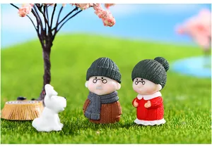 Vista dettagliata di figurine di coppia anziana in miniatura in un paesaggio di muschio invernale