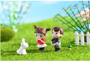 Detailed view of cute couple figurines on a mossy lawn for DIY miniature landscaping.