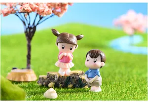 Close-up of mini resin couple figurines displayed in a lush park micro landscape