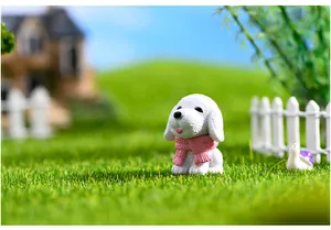Close-up of a white resin puppy figurine wearing a textured pink scarf ornament