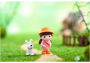 Gros plan d'une figurine de fille mignonne avec un chapeau orange et une miniature de chien blanc