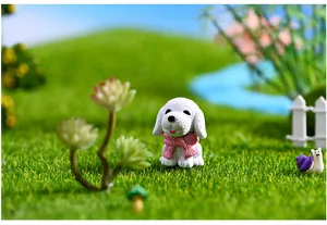 Miniature resin white puppy figurine with pink scarf in a lush green moss landscape