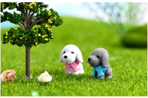 Miniature resin dog figurines with colorful scarves in a lush green grass landscape.