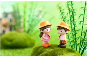 Gros plan de figurines de couple miniatures avec fruits confis en scène de mousse