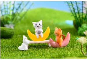 Primo piano di adorabili statuine di gatti su lune nascenti per paesaggi in miniatura