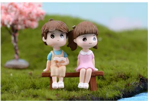 Cute couple resin figurines sitting on a wooden bench for DIY micro landscape garden
