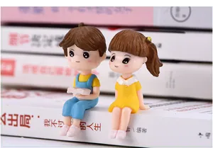 Detailed view of cute resin miniature boy and girl figurines for DIY micro landscapes.