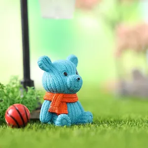 Statuina di mini orso blu con trama a maglia e piccolo decoro a sciarpa arancione
