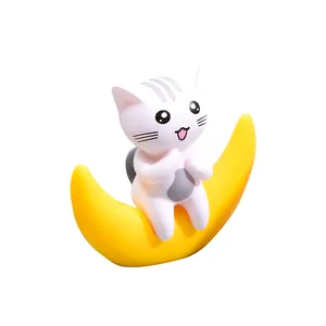 Simpatica statuina di gatto bianco seduto su una luna crescente gialla per decorazioni.