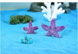 Macrodetail van paarse hars zeesterren in een blauw zand micro-landschap decoratie