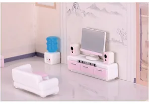 Vue détaillée d'un ensemble de meubles miniatures en résine avec TV et canapé rose et blanc