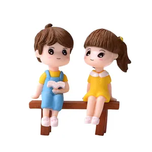 Adorable miniature resin couple figurines reading on a brown bench for succulent DIY