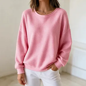 Close-up detail of women's pink waffle knit sweatshirt with a cozy texture