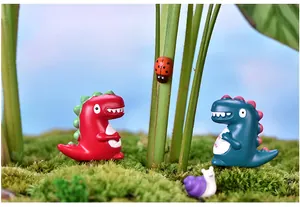 Nahaufnahme von niedlichen Harz-Dinosaurier-Miniaturen in einer Moos-Landschaft